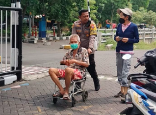 Layani Masyarakat yang Ingin Mencoblos, Kapolsek Gunung Anyar Bantu Dorong Kursi Roda Seorang Lansia